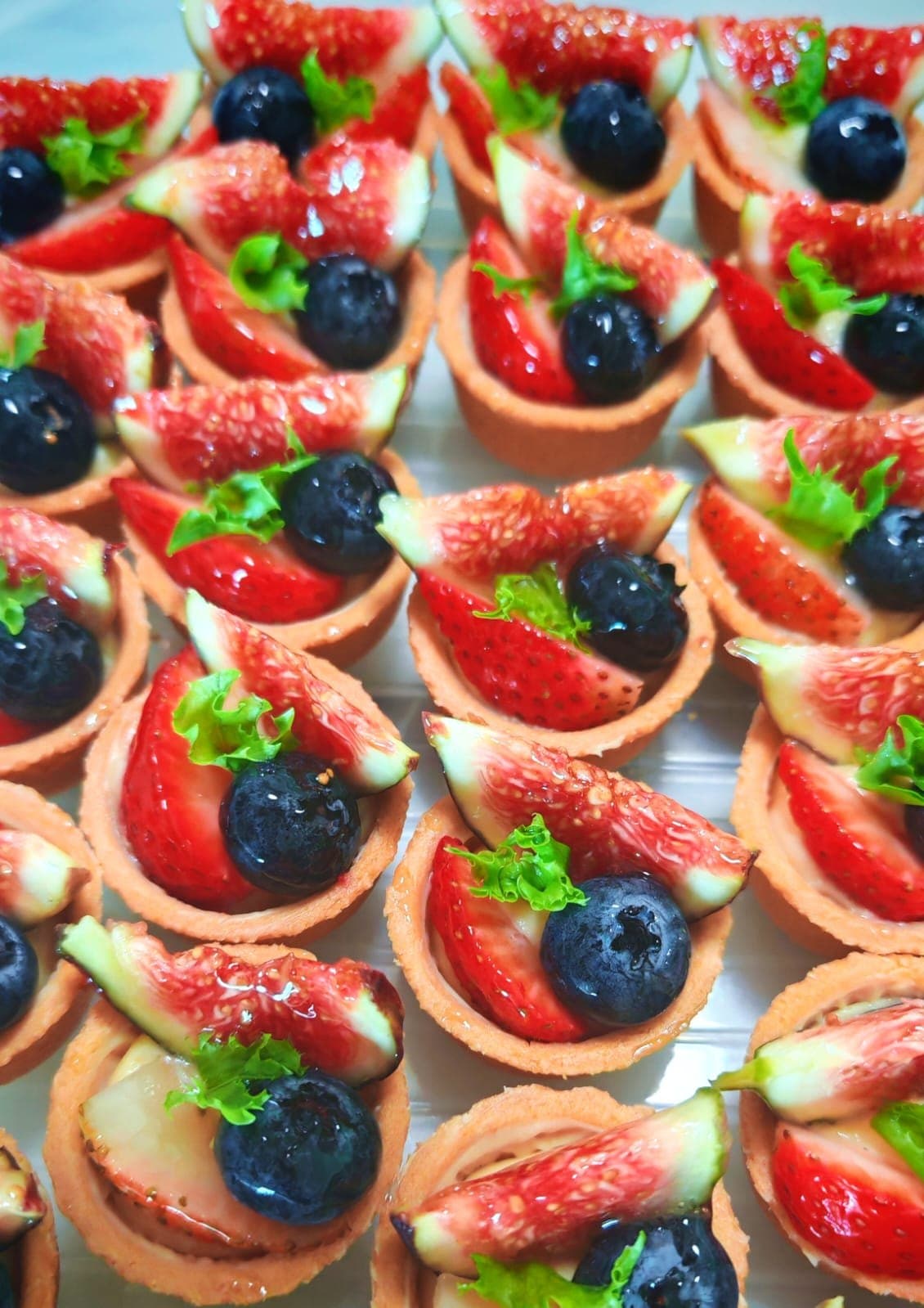 A Small Potato BIG Dream dessert table of fruit tartlets, quiches and canelés on marble-and-gold stands at a corporate reception
